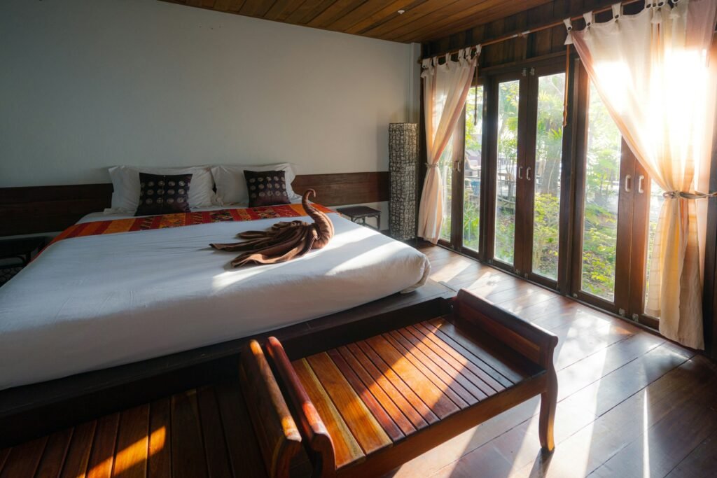 Sunlit bedroom with crisp white linen and warm wood floors